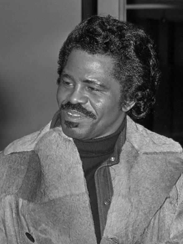 A black and white photo of James Brown in 1977